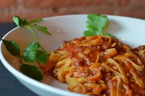 Tagliatelle pasta with rich bolognese sauce and fresh parsley.
