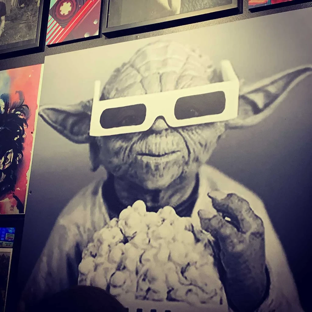 Black-and-white print of Yoda in 3D glasses eating popcorn.