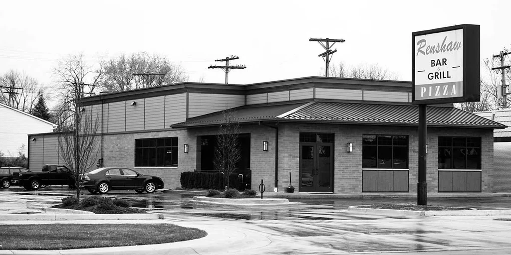 Black and white Renshaw Bar & Grill exterior, wet lot, bare trees.
