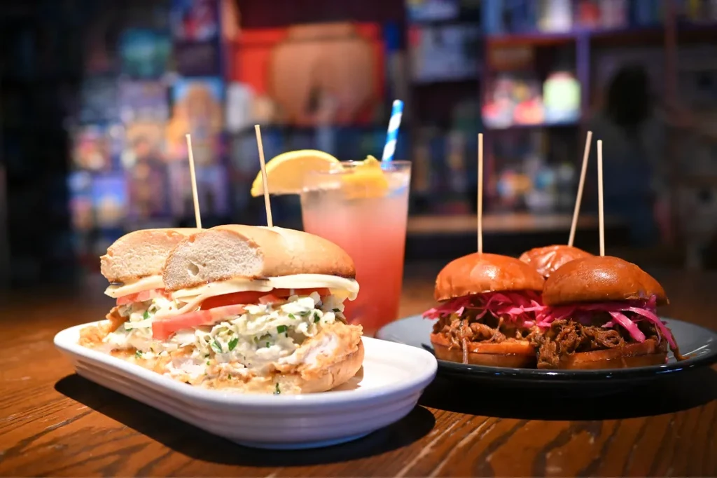 Fried chicken sandwich, pink drink, and three pulled meat sliders.