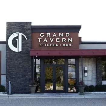 Grand Tavern Kitchen + Bar's modern stone and glass entrance.