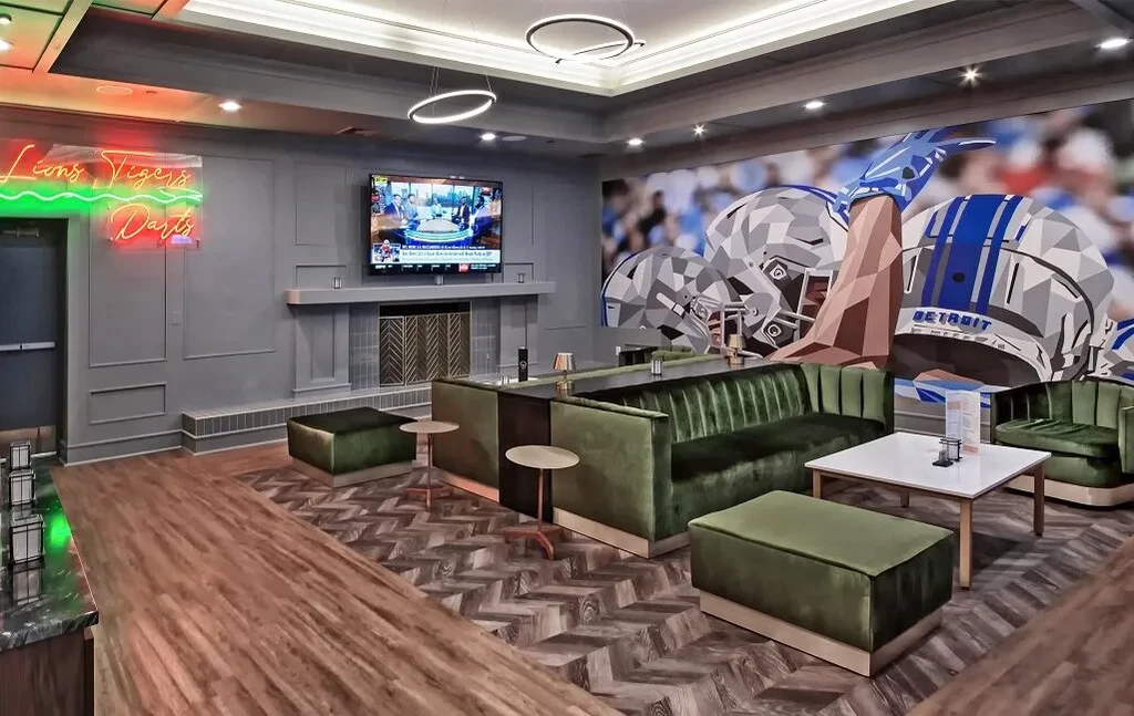 Stylish sports lounge with velvet sofas, chevron floor, and neon sign.