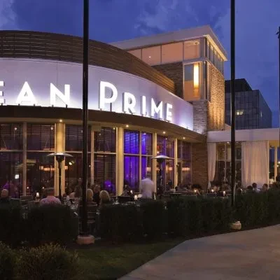 OCEAN PRIME restaurant exterior at dusk with purple lights and outdoor patio.