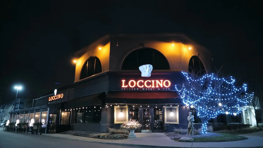 Loccino Italian Grill & Bar at night, chef hat sign, blue lights.