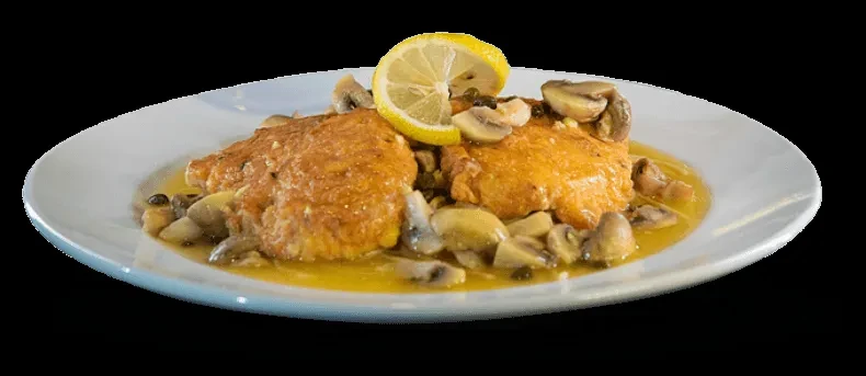 Golden-brown chicken or fish, yellow sauce, mushrooms, capers, and lemon slice.