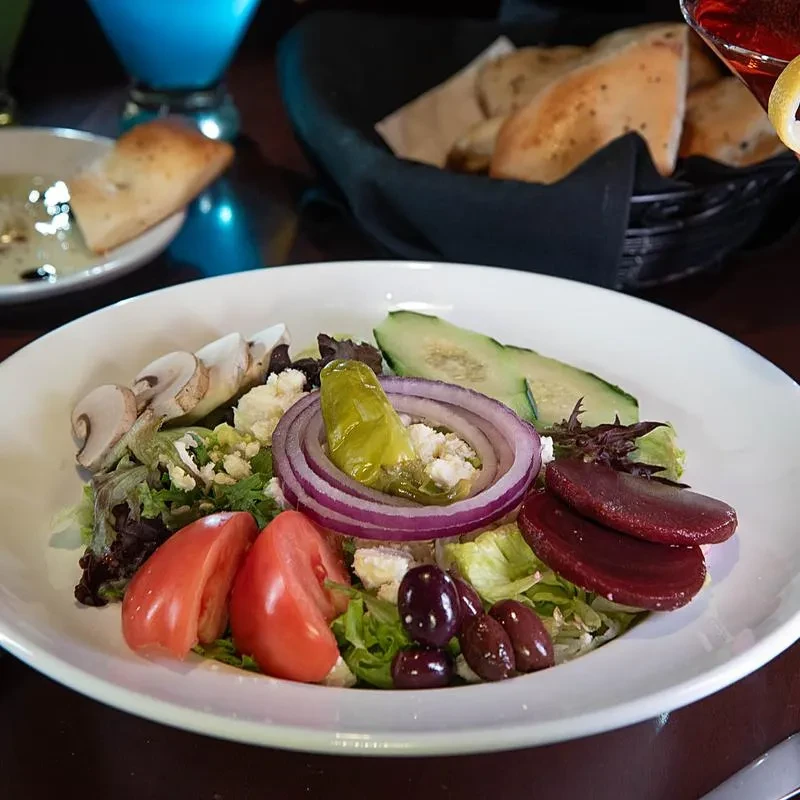 Colorful salad with fresh vegetables, feta, olives, and pickled beets.