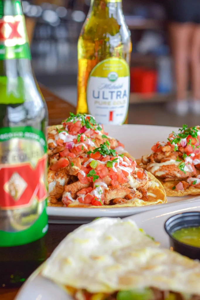 Tacos with pico de gallo, Dos Equis, and Michelob beer bottles.