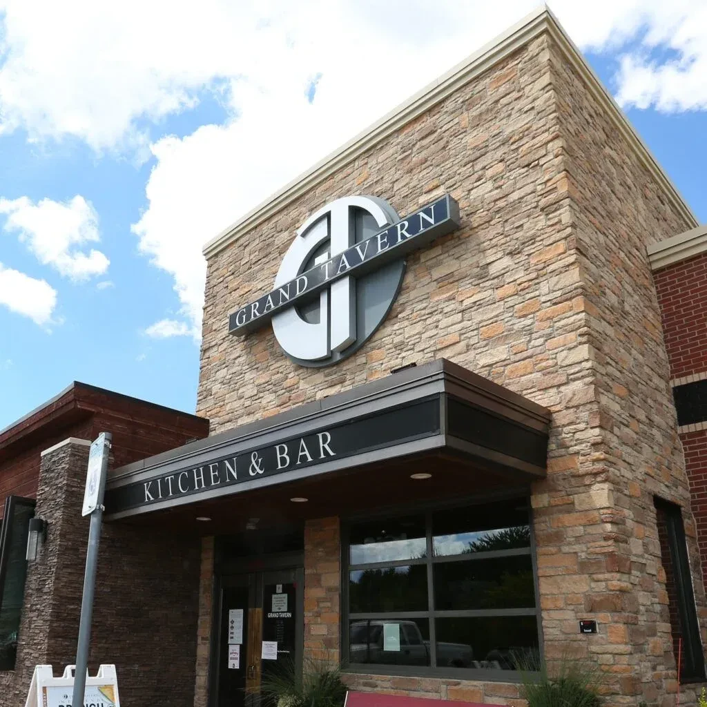 Grand Tavern Kitchen & Bar exterior: modern stone facade, GT sign.