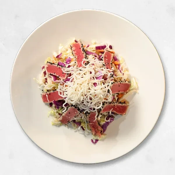 Colorful seared tuna salad with cabbage and crispy noodles.