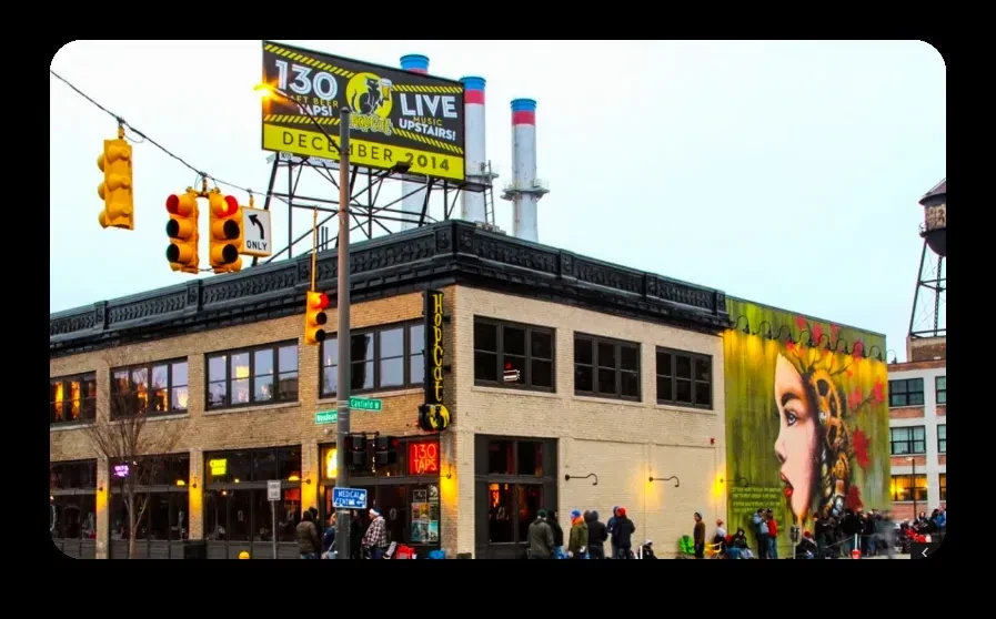 Street scene with Hopcat bar, colorful mural, and industrial backdrop.