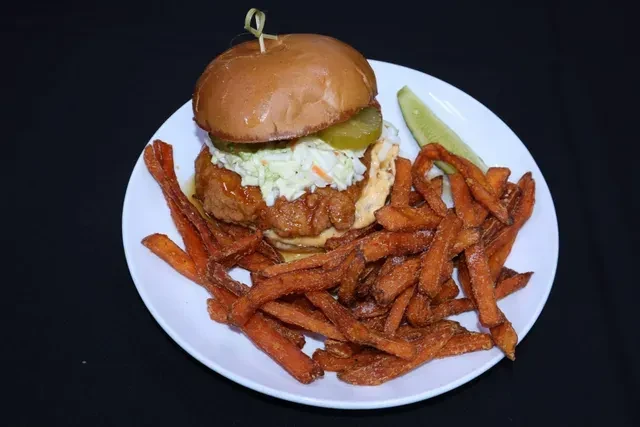 Golden fried chicken sandwich, coleslaw, pickles, sweet potato fries, sauce.