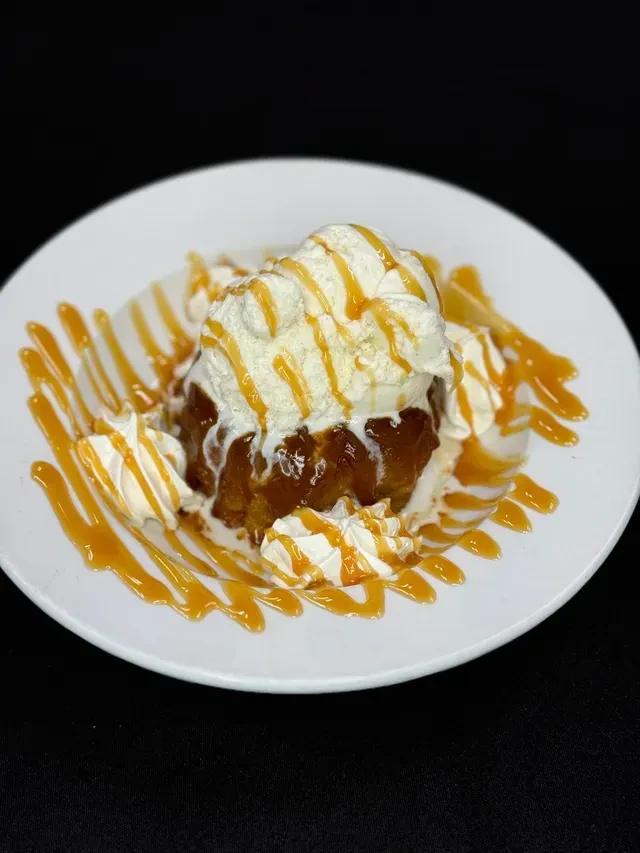 Warm baked dessert with melting vanilla ice cream, whipped cream, caramel sauce.