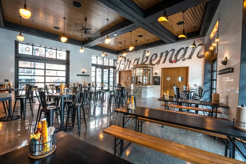 Empty modern restaurant interior with 'Brakeman' mural and varied seating.