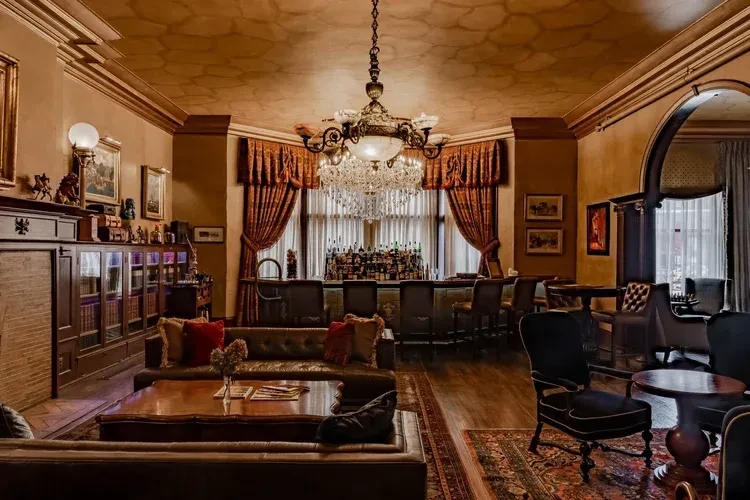 Luxurious hotel bar with a crystal chandelier and elegant seating.