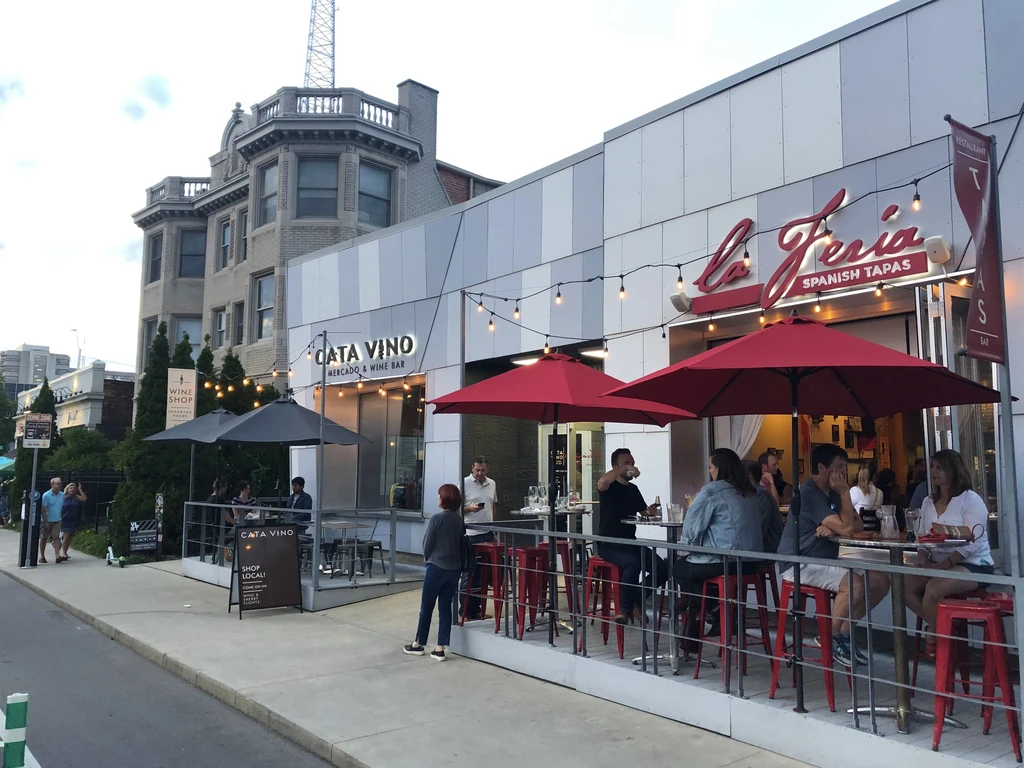 Lively outdoor dining at La Feria Tapas and Cata Vino at dusk.