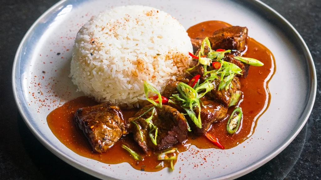 Seasoned rice, braised meat in rich sauce, scallions and chili.