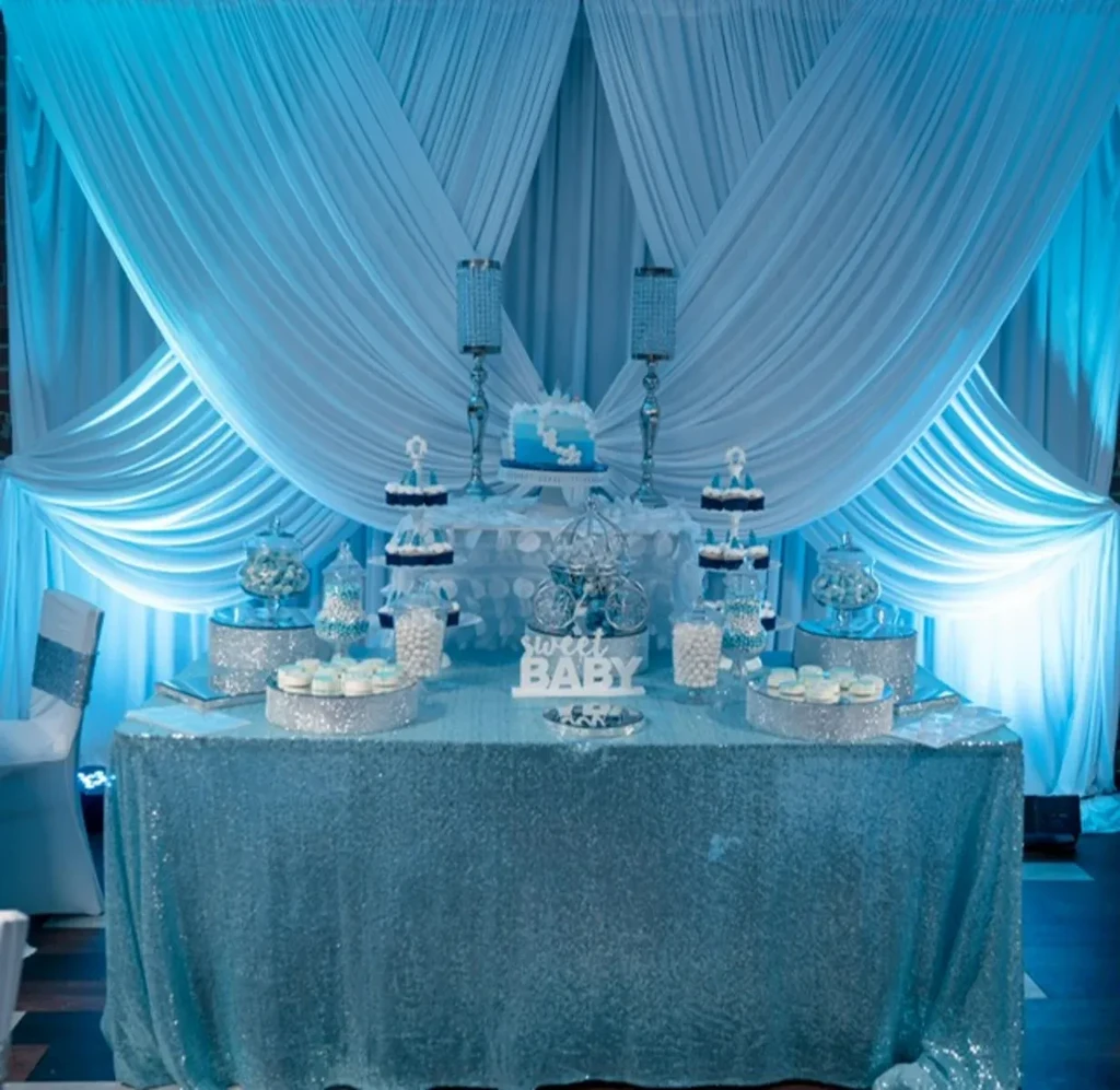 Elegant baby shower dessert table with blue and white treats.