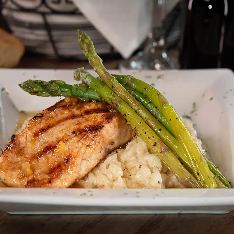 Glazed grilled salmon with risotto, asparagus, and citrus zest.