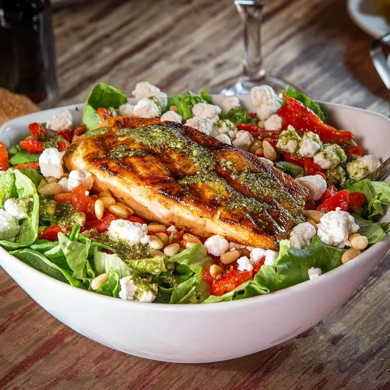 Grilled fish salad with pesto, feta, roasted peppers, and pine nuts.