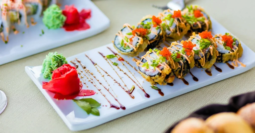 Crispy tempura sushi rolls garnished with roe, wasabi, and pickled ginger.