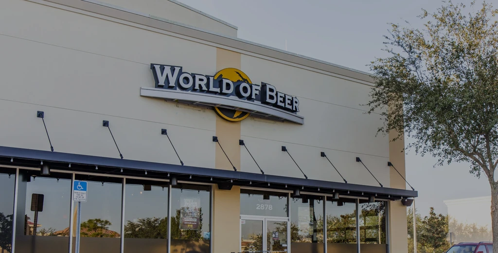 Facade of "WORLD OF BEER" restaurant with a prominent sign and yellow globe.