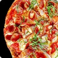 Close-up pizza with pepperoni, sausage, cheese, and green herbs.