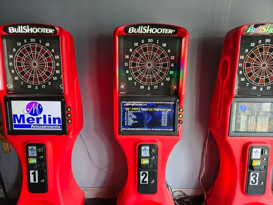 Three red BullShooter electronic dartboards against a gray wall.