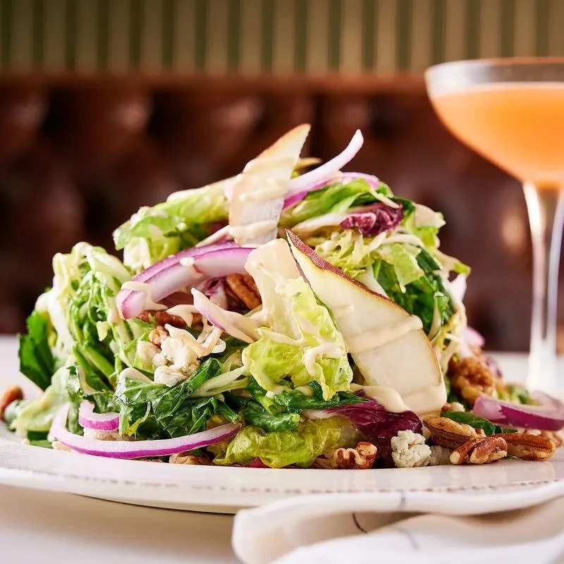 Vibrant salad with greens, pear, blue cheese, pecans, creamy dressing.