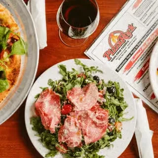 Overhead: Salad with meat, pizza, red wine, Pizzeria Rock menu.