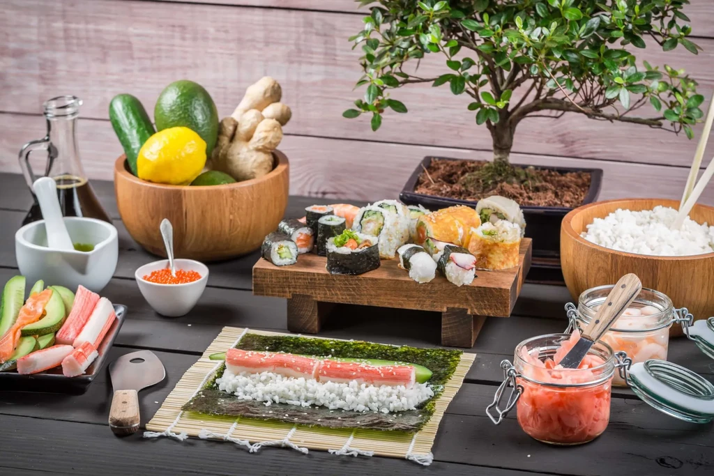 A rustic spread of sushi and ingredients for making sushi rolls.