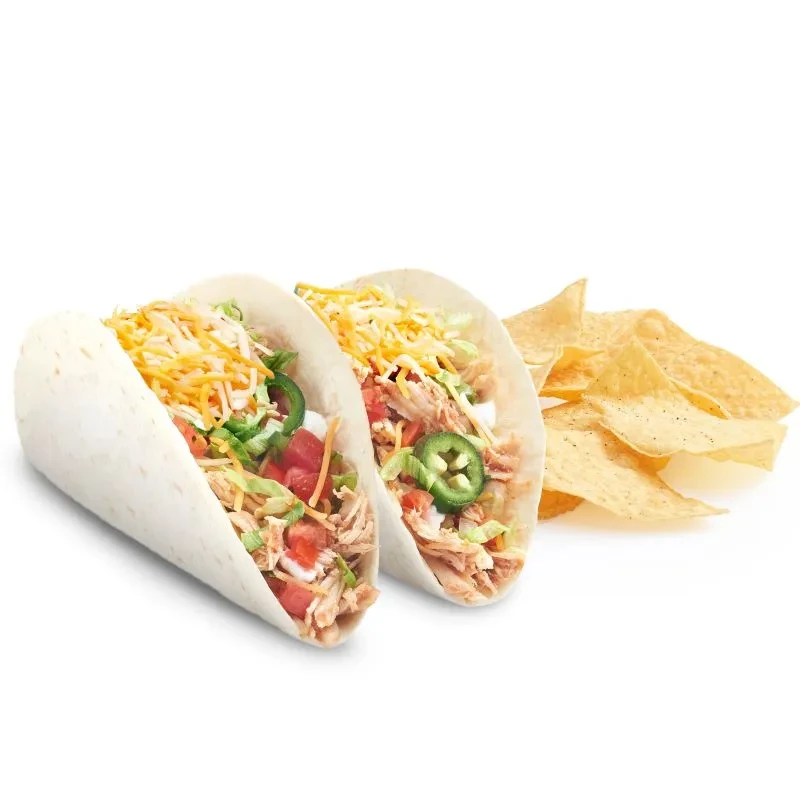 Close-up of two chicken soft tacos with tortilla chips on white.