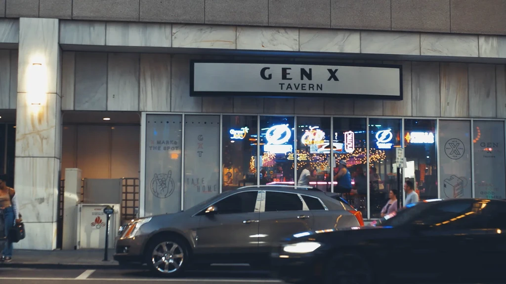Gen X Tavern's brightly lit exterior at night, with street activity.