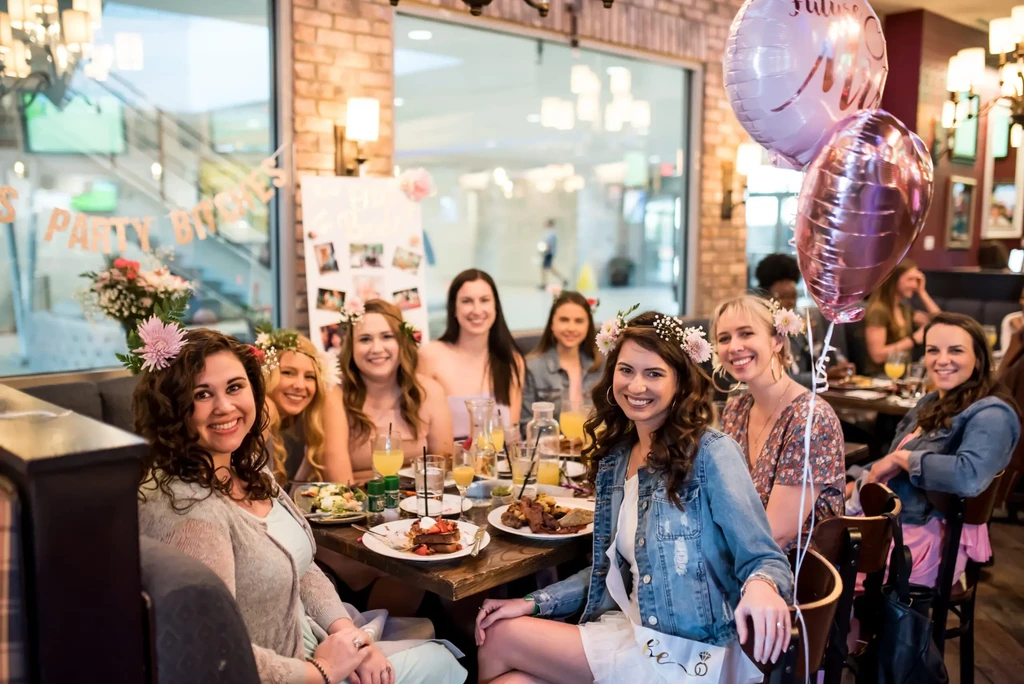 Women in floral headpieces celebrating a 'Future Mrs.' party with food.
