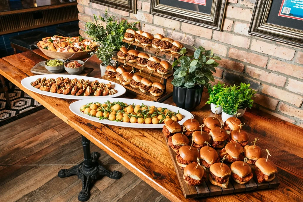 Buffet-style spread of diverse finger foods on a rustic wooden table.