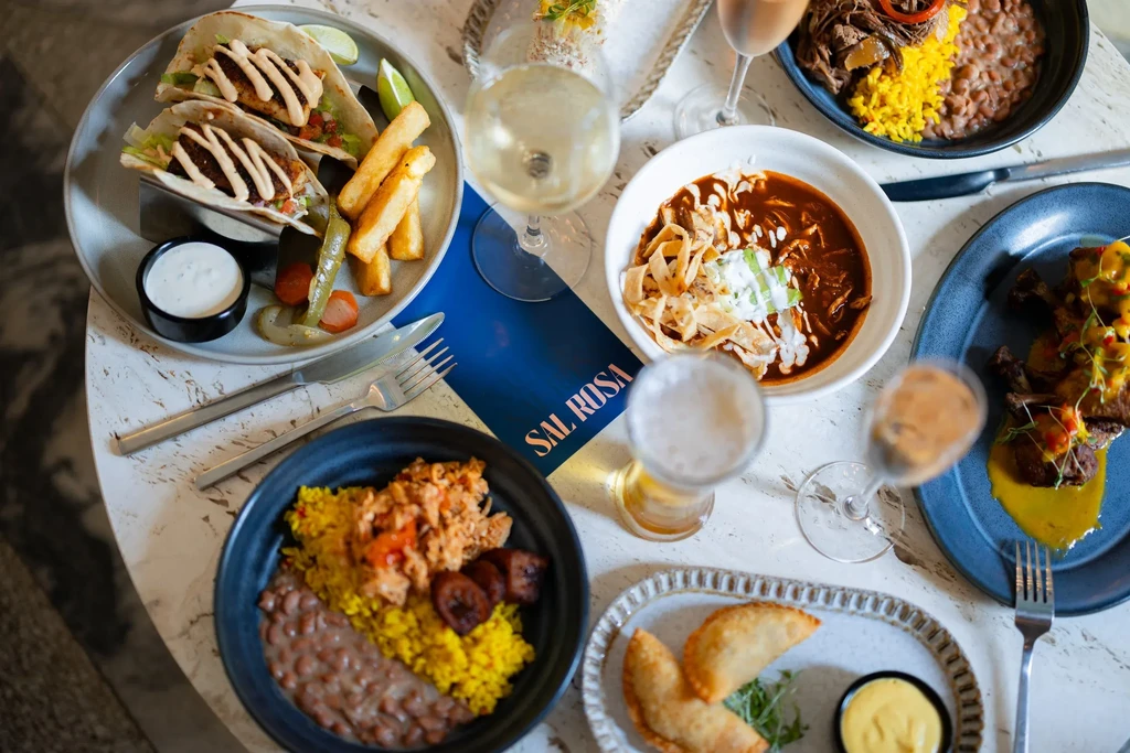 Top-down view of a table with diverse Latin American food and drinks.