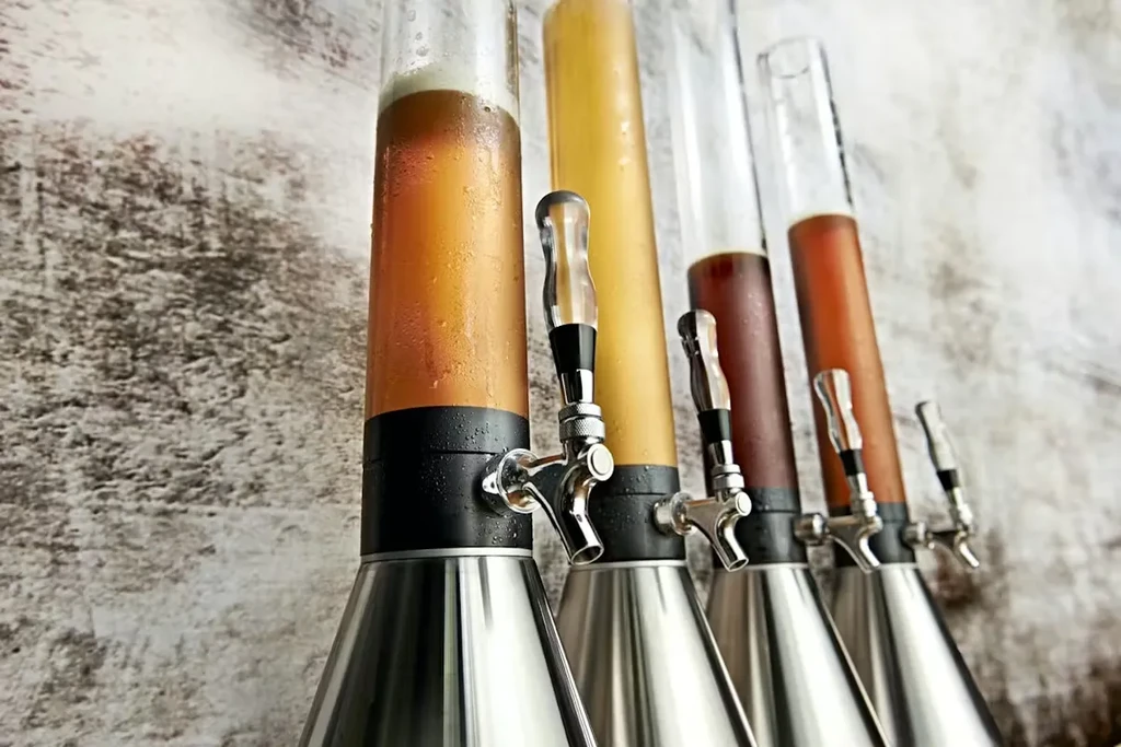 Five tall beer towers displaying different colored cold liquids.