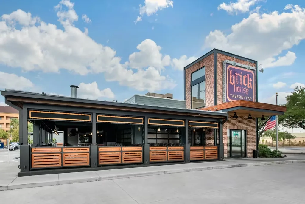 Modern Brick House Tavern + Tap exterior, dark metal, brick, and patio.
