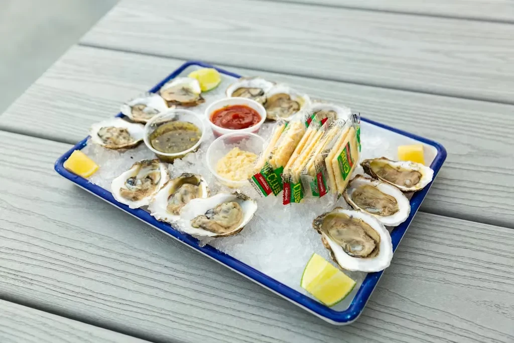 Fresh oysters on crushed ice with lemon, lime, crackers, and sauces.