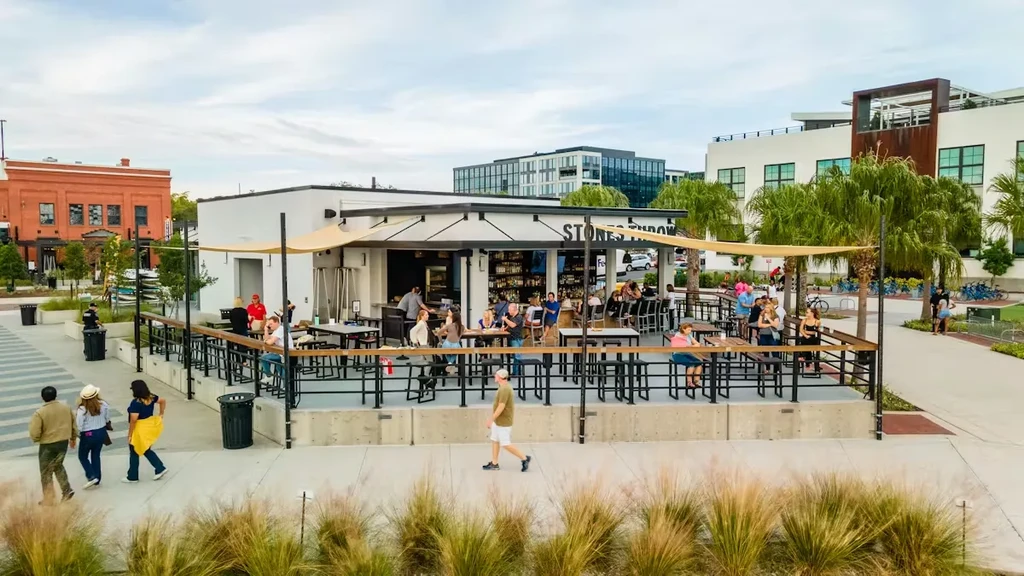 Elevated view of modern 'STONE'S THROW' restaurant with bustling outdoor patio.