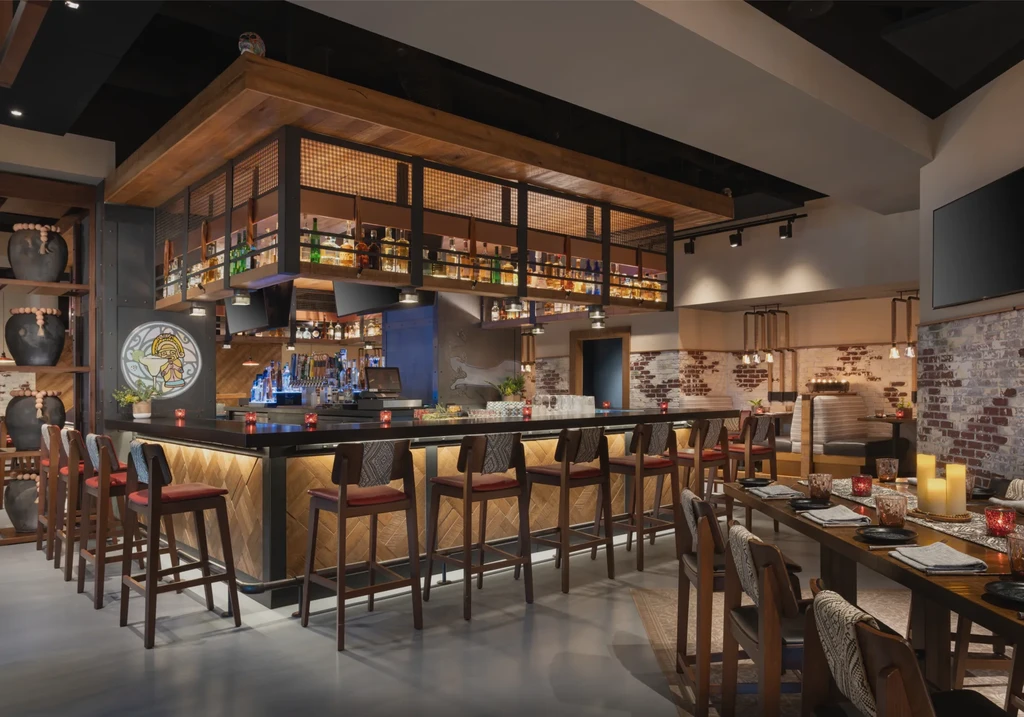 Warm, contemporary rustic restaurant interior with bar and dining areas.