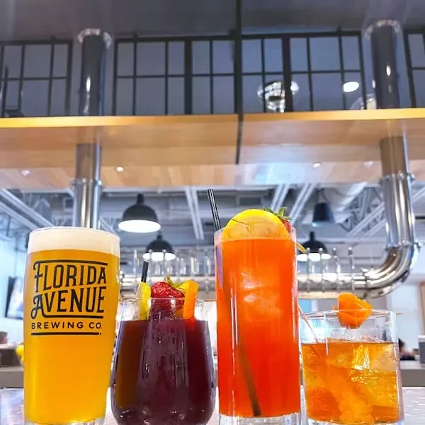 Beer and three cocktails on a bar in a modern industrial brewery.