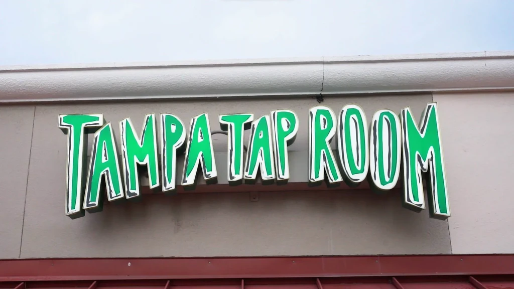 Outdoor TAMPA TAP ROOM sign featuring playful green 3D letters.