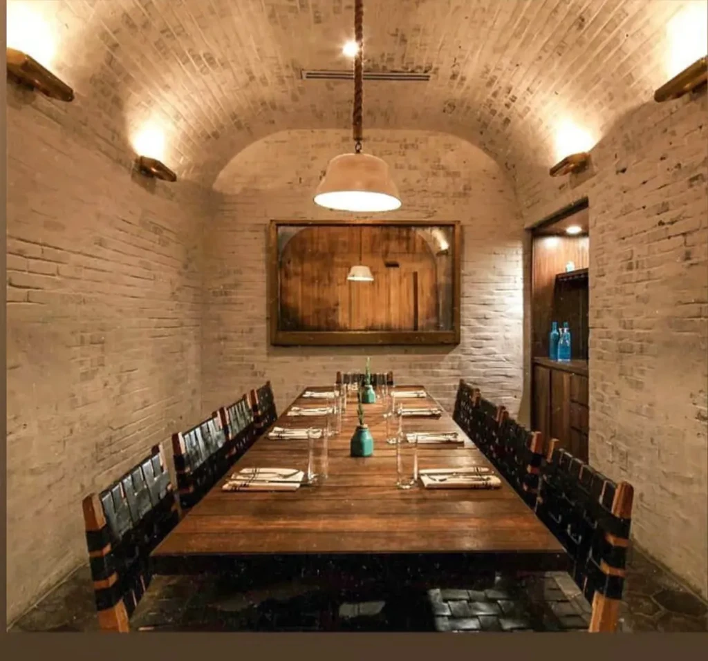 Arched brick private dining room with long, elegantly set table.