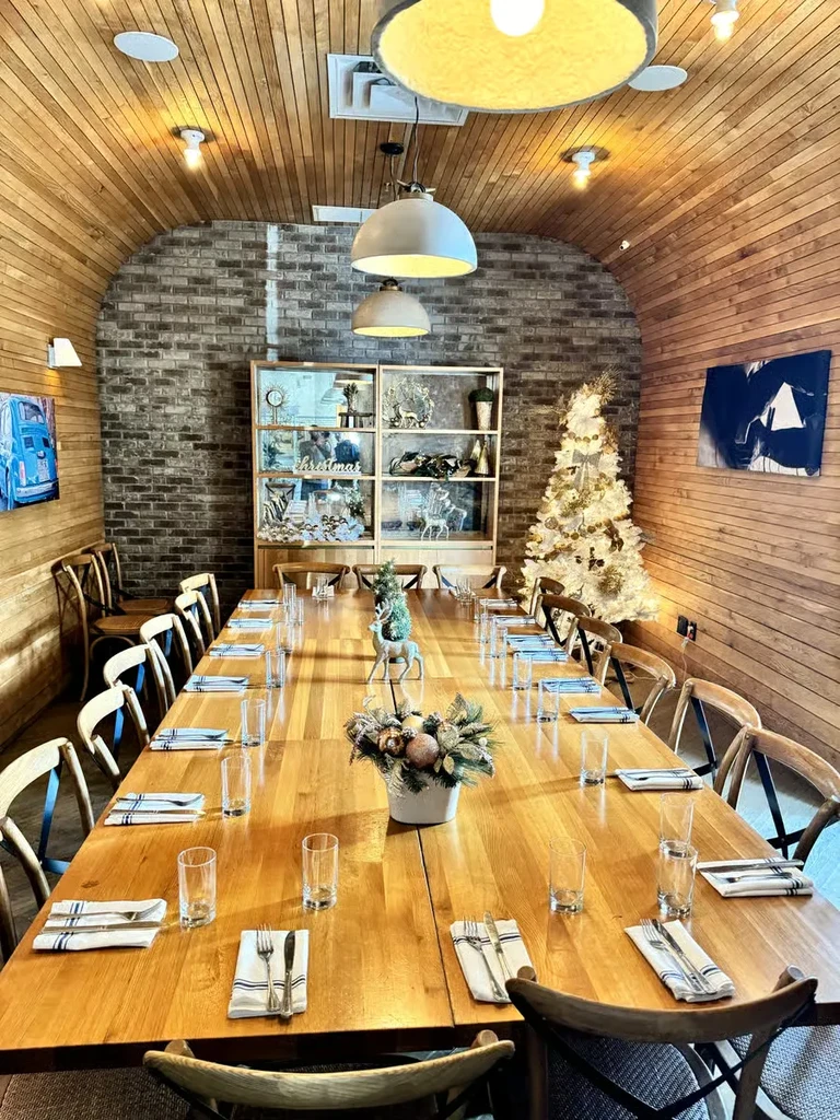 Elegantly set wooden dining table in a rustic holiday room.