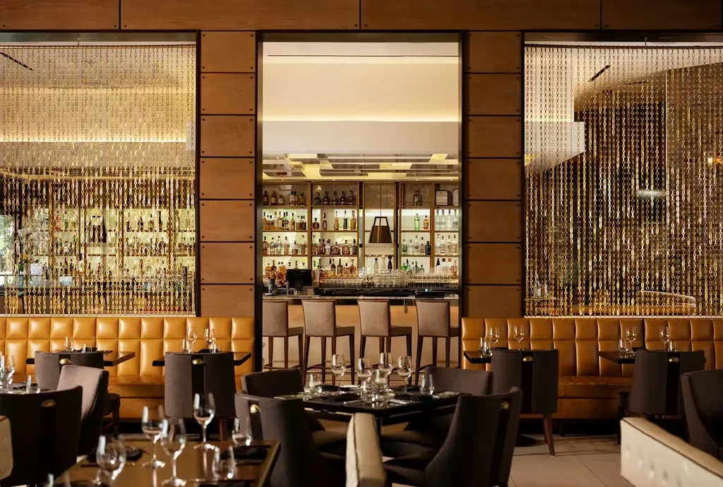 Sophisticated restaurant interior with a leather booth and backlit bar.