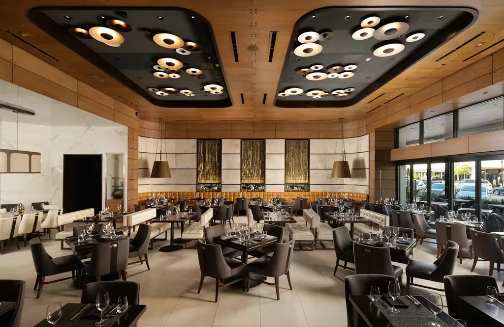 Modern, upscale restaurant dining room with set tables and no people.