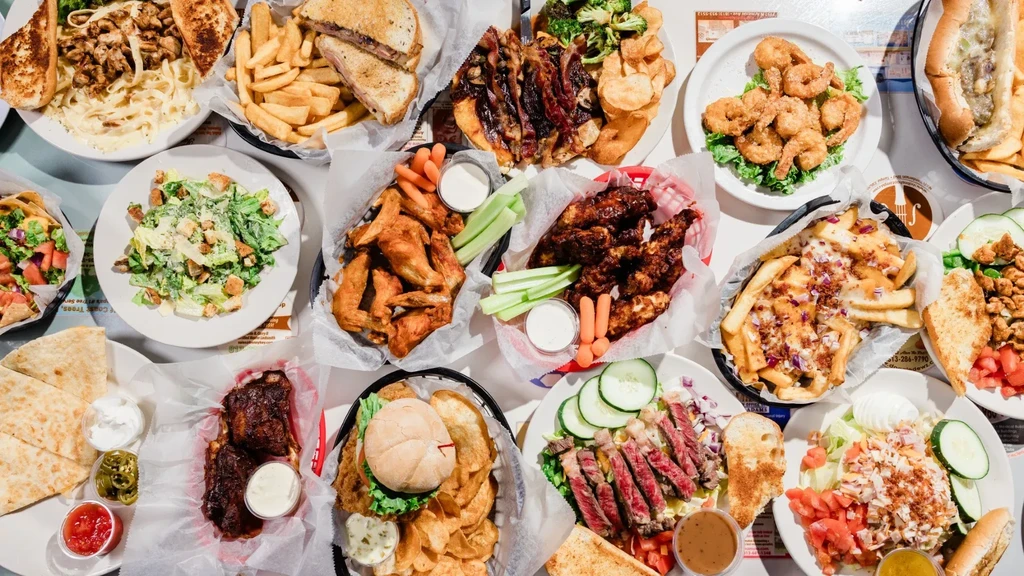 Flat lay of a table spread with a large variety of restaurant food.