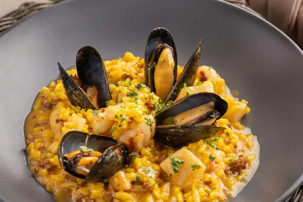 Vibrant seafood risotto or paella, with mussels, shrimp, and green herbs.