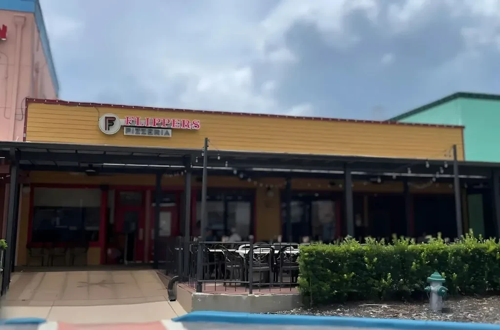 Flippers Pizzeria's yellow building, red trim, and covered outdoor patio.