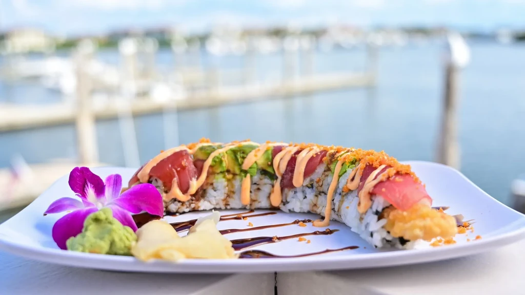 Sushi roll with tuna, avocado, purple orchid, overlooking a marina.